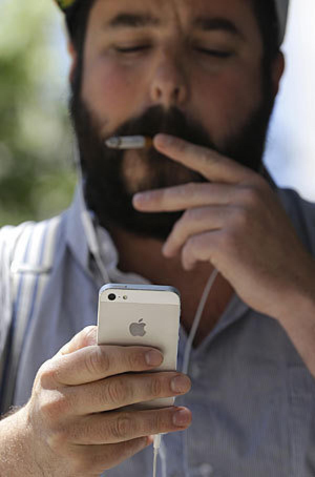 Brian Bocchino uses his iPhone at Union Square in San Francisco on Wednesday. San Francisco's district attorney and New York's attorney general say they will meet with major cellphone manufacturers to push the industry to do more to protect consumers from violent crimes connected to cellphone thefts.
