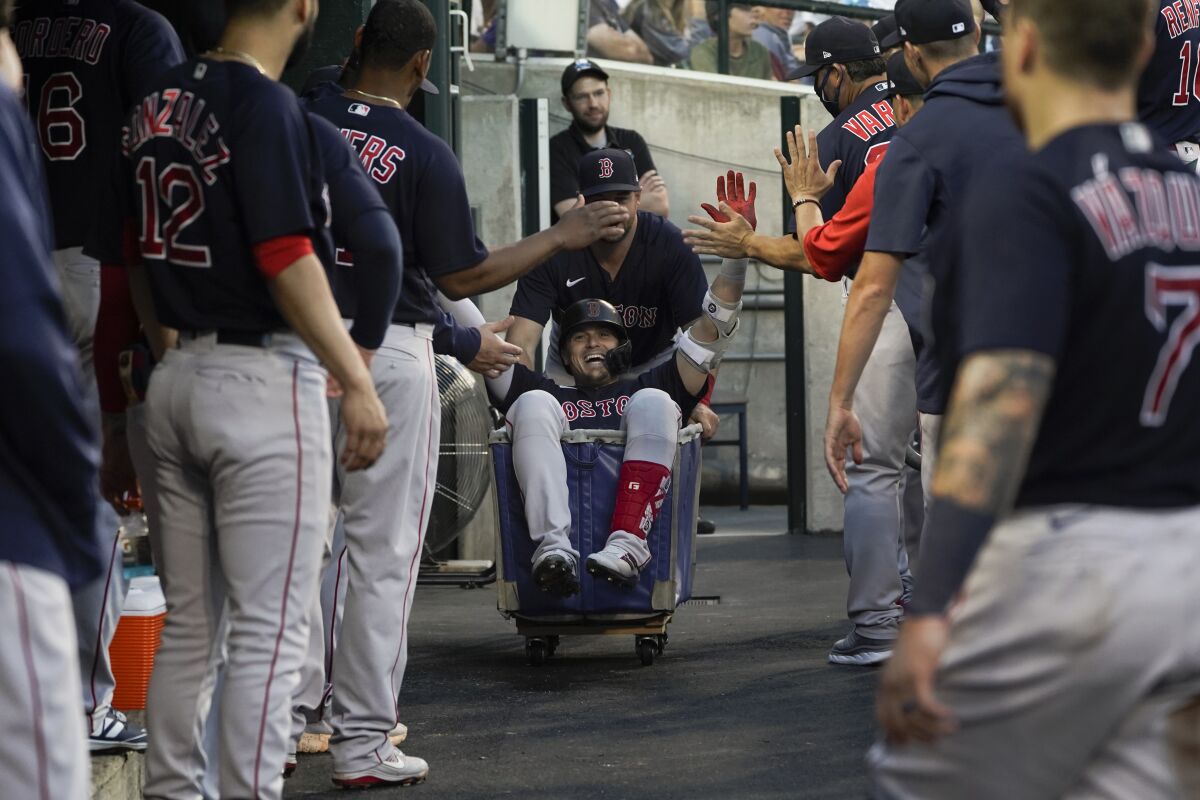 Boston Red Sox's Enrique Hernandez is pushed in a cart in the dugout after hitting a two-run home run against the Detroit Tigers in the fifth inning of a baseball game in Detroit, Wednesday, Aug. 4, 2021. (AP Photo/Paul Sancya)