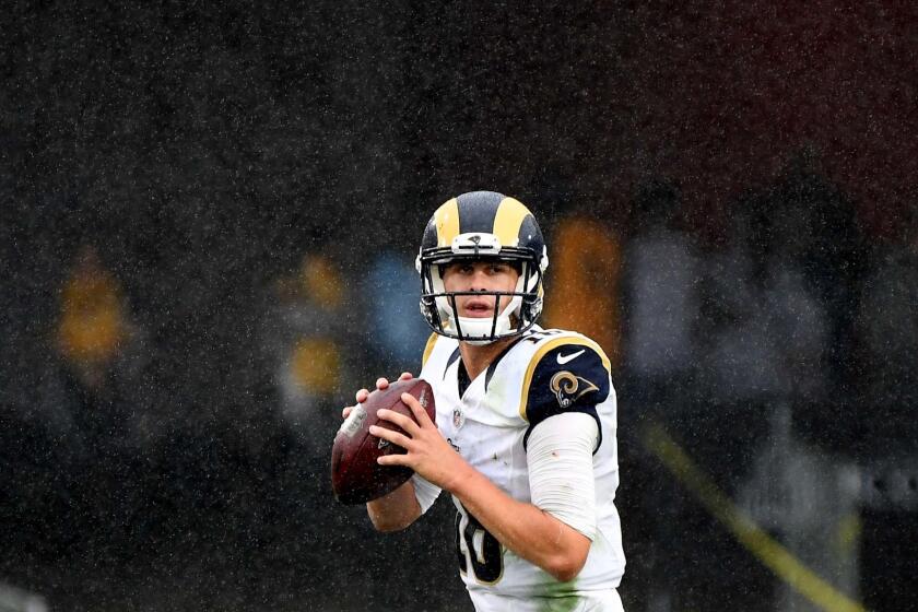 With the rain coming down, Rams quarterback Jared Goff looks for a receiver against the Dolphins in the third quarter.