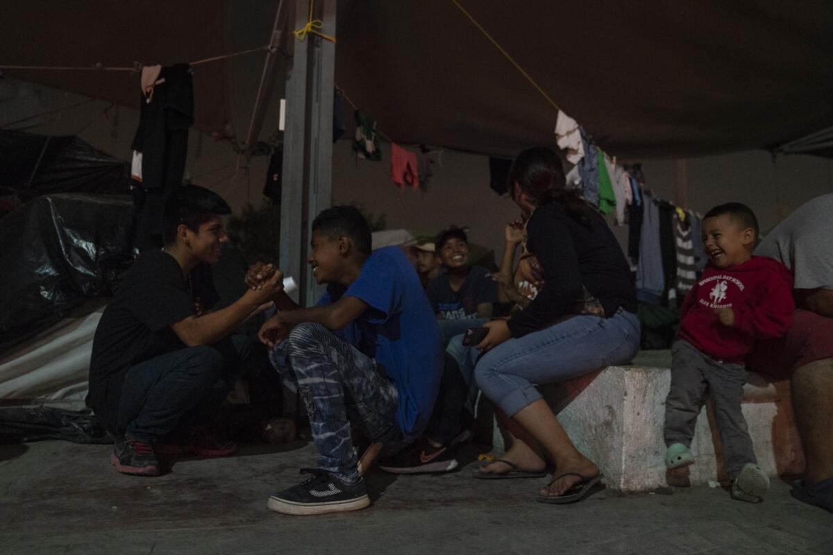 Adolescentes centroamericanos que buscan asilo juegan cerca del Puente Internacional Gateway en Matamoros, México.