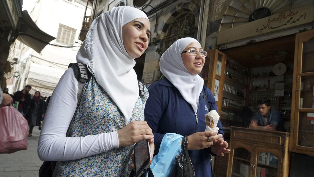 Ghina Allain, left, and her sister Hannah Allain stroll the ancient Souk al-Silah. "Our spirit isn't very high right now," Ghina Allain said of the situation in Syria.