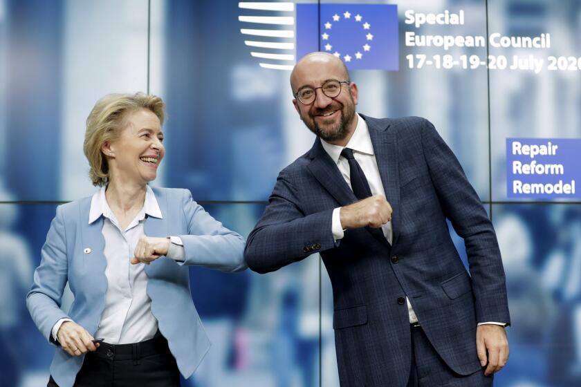 European Commission President Ursula von der Leyen, left, and European Council President Charles Michel bump elbows after addressing a media conference at an EU summit in Brussels, Tuesday, July 21, 2020. Weary European Union leaders finally clinched an unprecedented budget and coronavirus recovery fund early Tuesday, finding unity after four days and as many nights of fighting and wrangling over money and power in one of their longest summits ever. (Stephanie Lecocq, Pool Photo via AP)