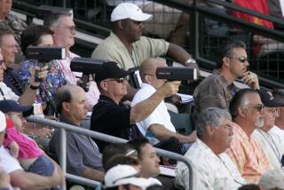 MLB scouts sit in the stands and point radar guns at the field during a 2007 spring training game 