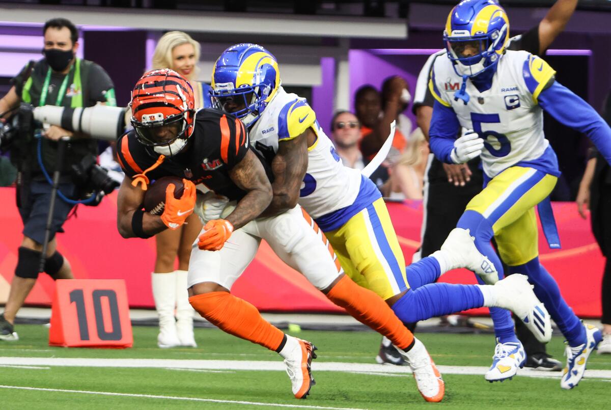 Cincinnati Bengals wide receiver Ja'Marr Chase is tackled by Rams safety Nick Scot.