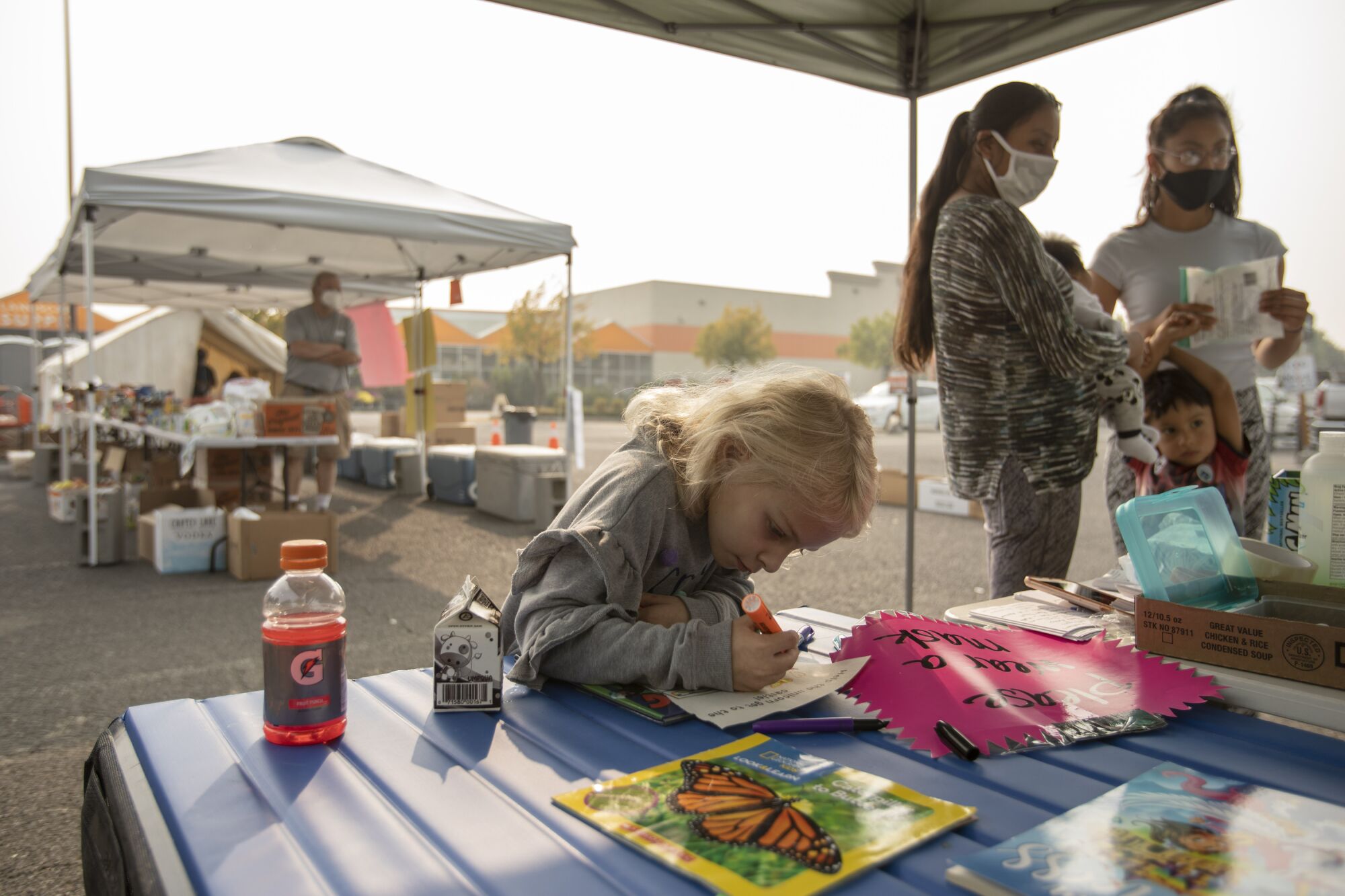 Cheyenne Brewer, age 7, who lost her home in the Almeda fire, colors at a donation center in Phoenix, Ore.