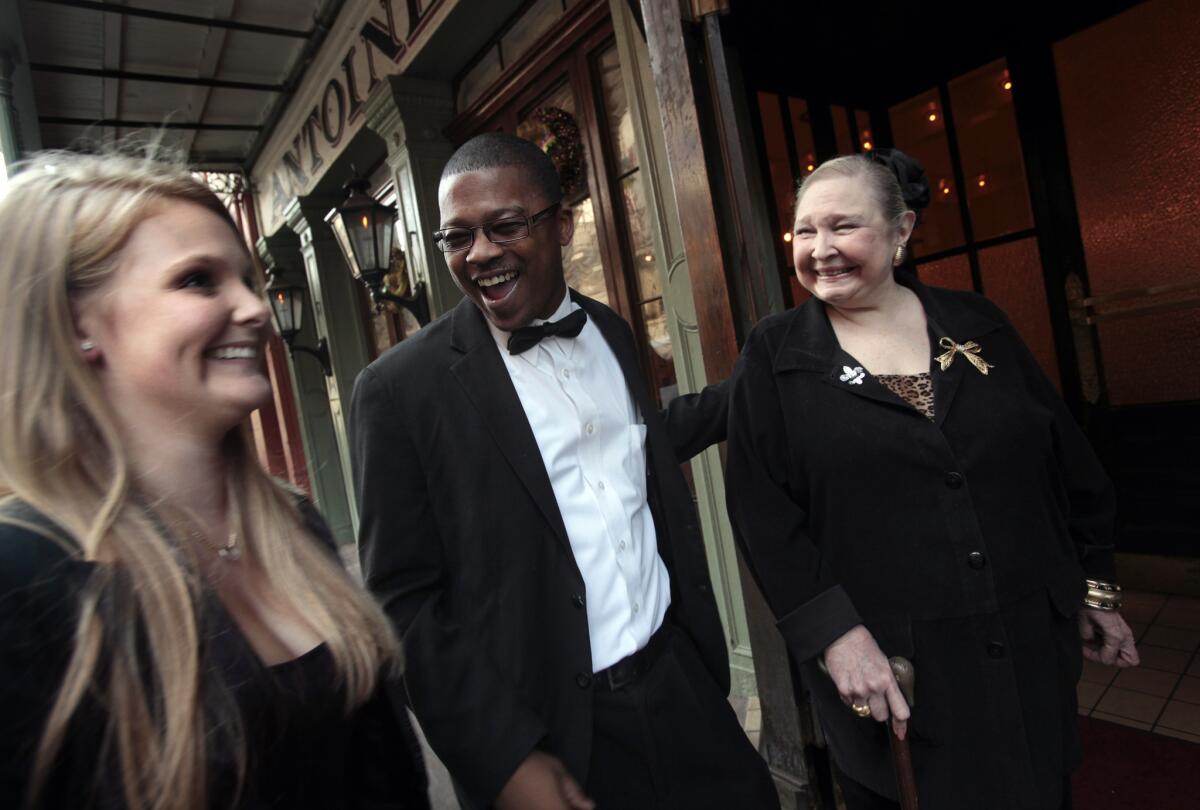 Waiter Derrick Roberts, center, jokes around with Casie Blount and her grandmother as he arrives for work.