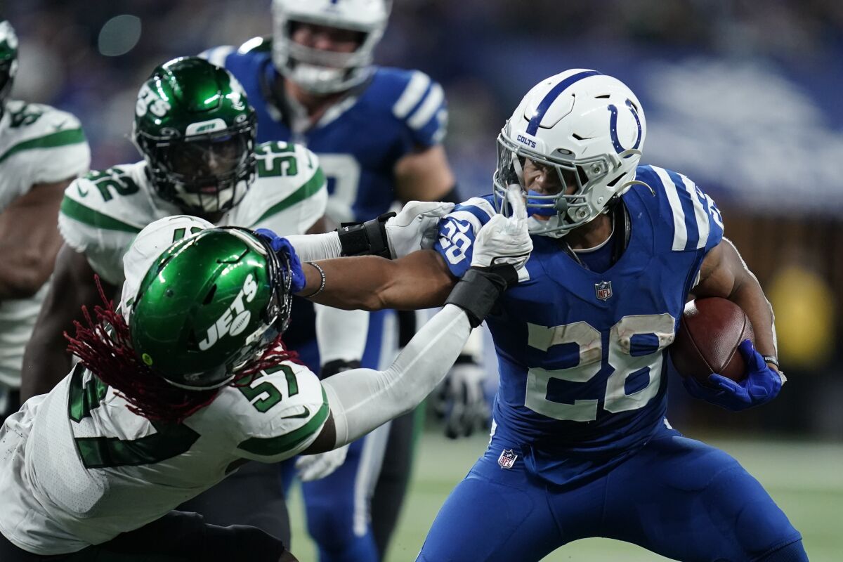Indianapolis Colts' Jonathan Taylor (28) runs past New York Jets' C.J. Mosley (57) during the second half of an NFL football game, Thursday, Nov. 4, 2021, in Indianapolis. (AP Photo/Michael Conroy)
