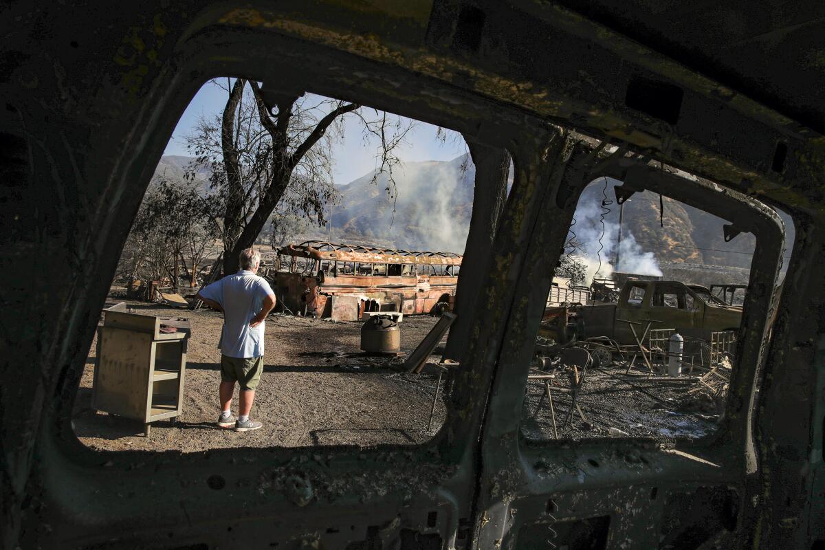 Tim Handman surveys damage to his property caused by the fast-moving South fire.