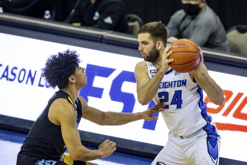 Creighton guard Mitch Ballock (24) looking to make a move against Marquette guard D.J. Carton (21) in the second half during an NCAA basketball game on Monday, Dec. 14, 2020, in Omaha, Neb. (AP Photo/John Peterson)