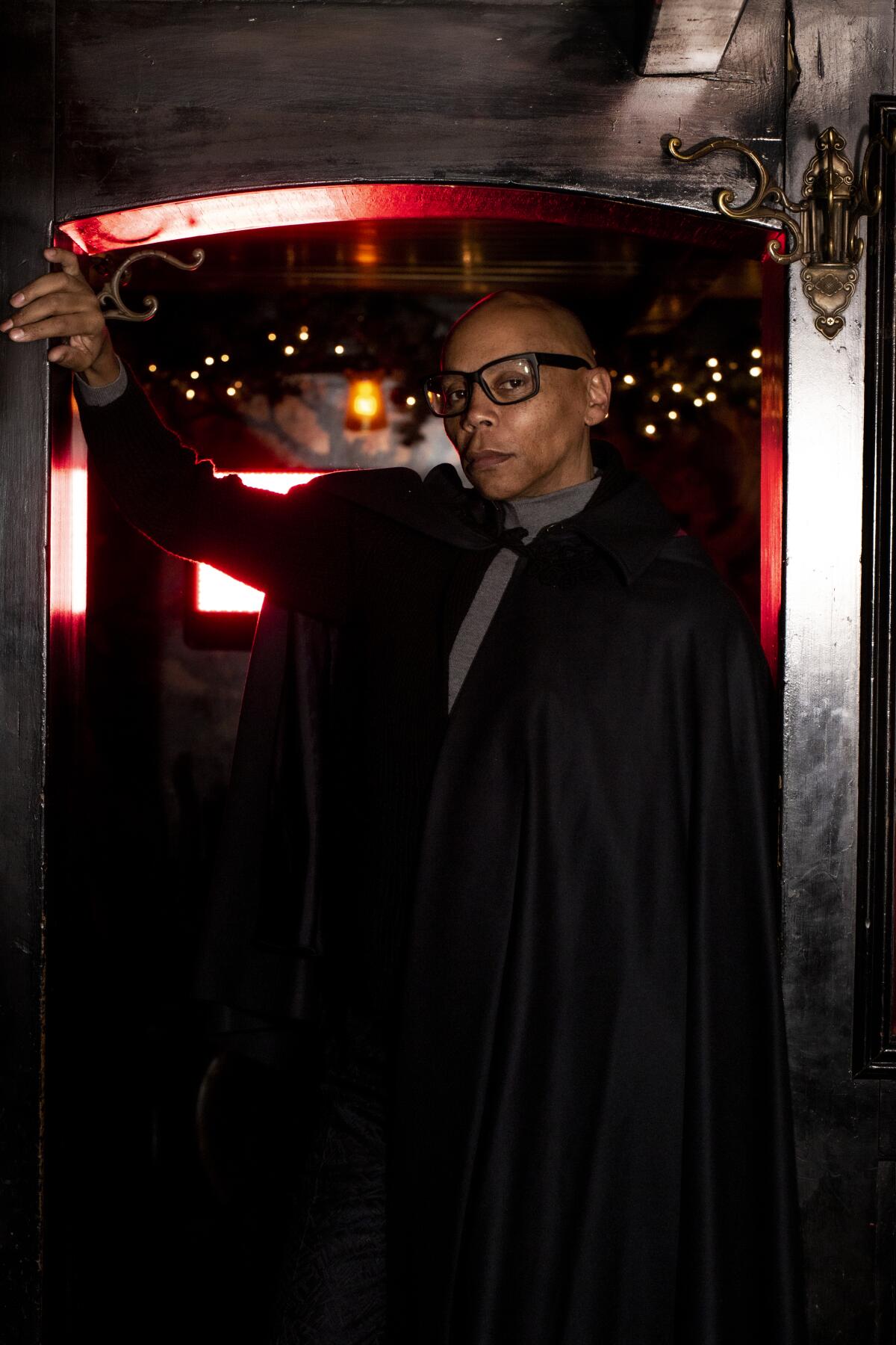 A man in glasses posing in a doorway