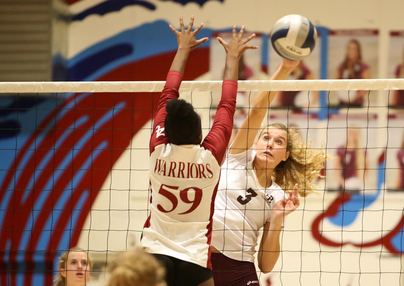 Laguna Beach High hitter Sophia Reavis puts the ball away past Mission Hills Alemany blocker Lindsey Felton during the quarterfinals of the CIF Southern Section Division 3 playoffs at home on Wednesday.