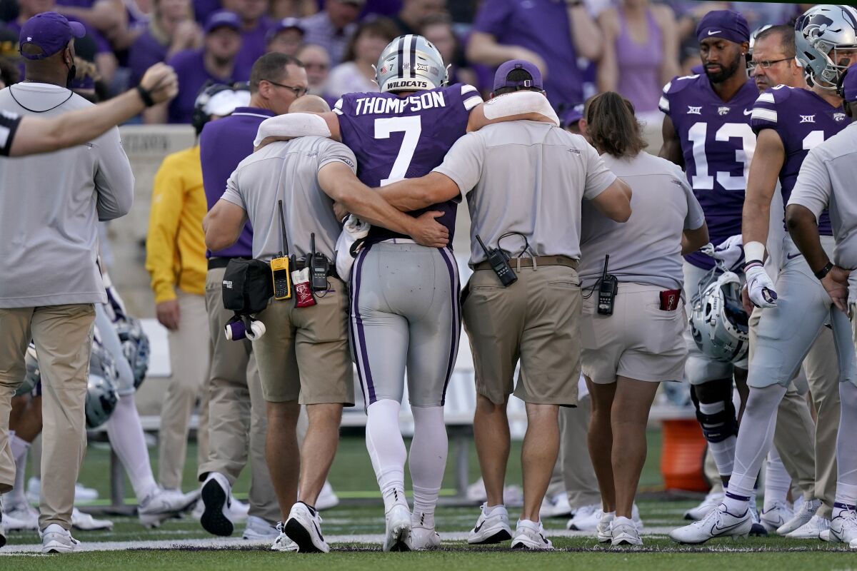 FILE- In this Saturday, Sept. 11, 2021, file photo, Kansas State quarterback Skylar Thompson (7) is helped off the field after getting injured in the first half of an NCAA college football game against Southern Illinois in Manhattan, Kan. Thompson was having a good start to his sixth year in Kansas State's program before a knee injury that will keep him out indefinitely. (AP Photo/Charlie Riedel, File)