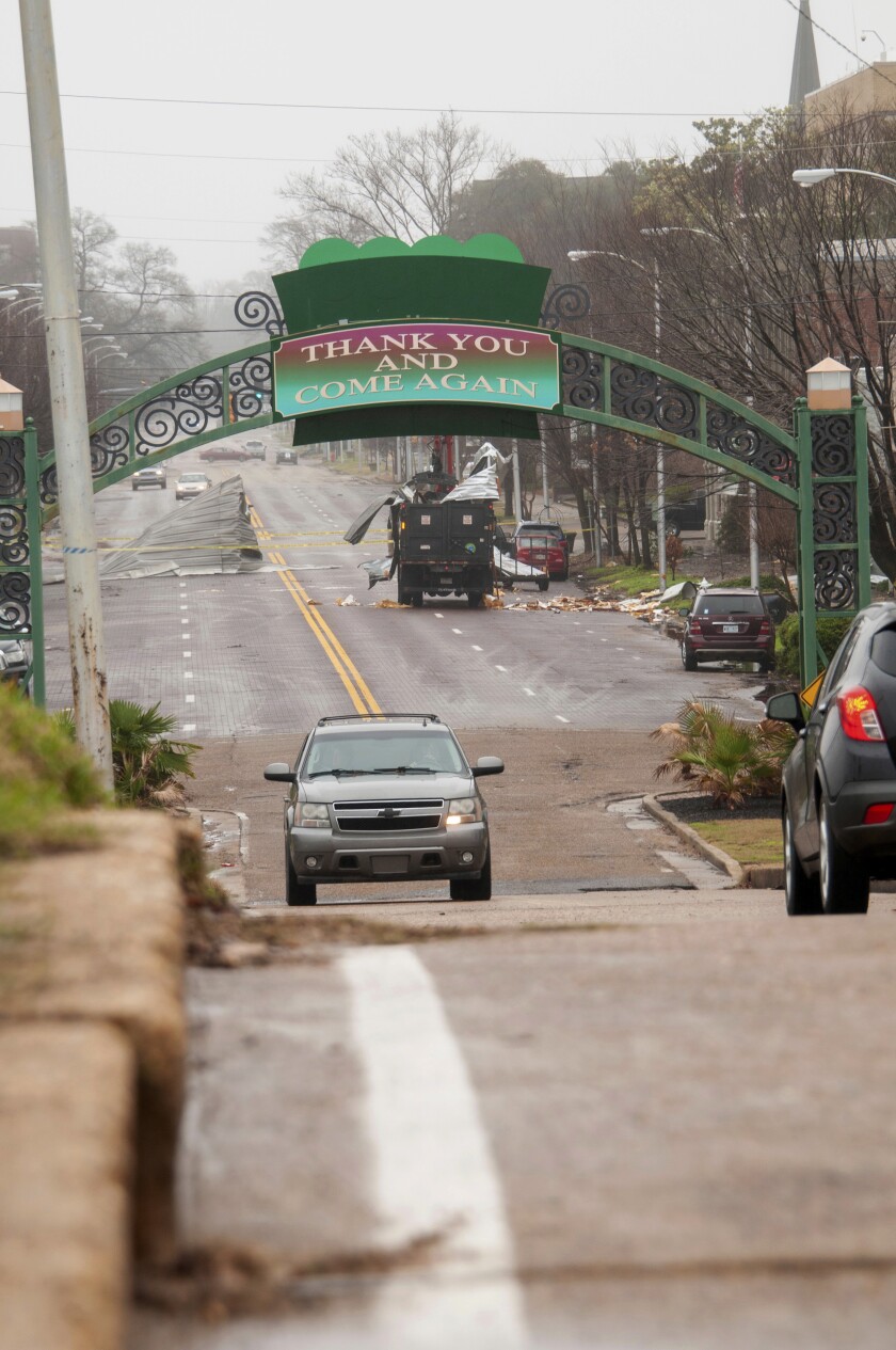 City of Greenville, Miss., trucks and employees, work to clean up debris from a storm along Main Street, Saturday, Jan. 11, 2020, in Greenville, Miss. Severe storms swept across parts of the U.S. South and were blamed for deaths, destruction and damages. (Jon Alverson/The Delta Democrat-Times via AP)