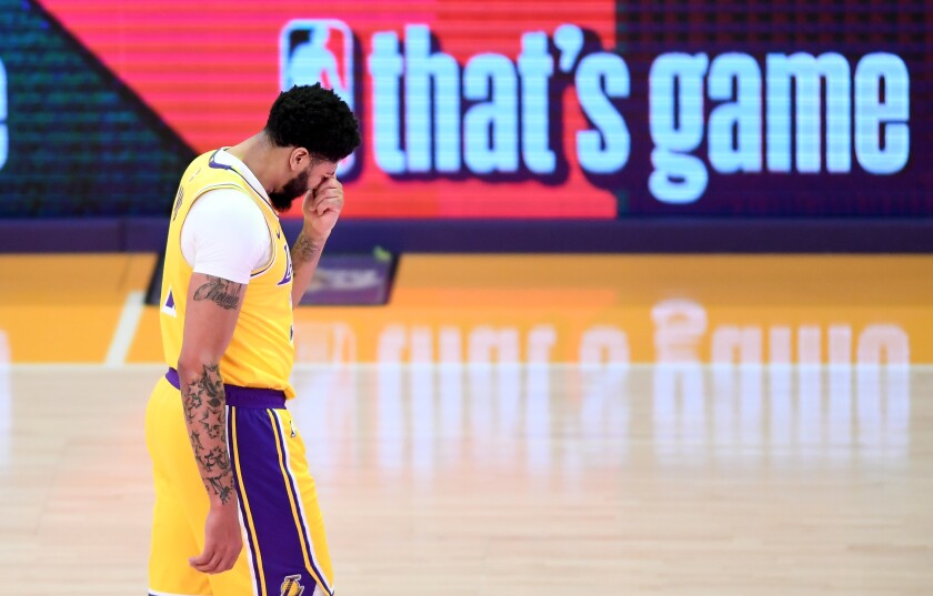 Lakers forward Anthony Davis holds is nose after getting hit against the Phoenix Suns in Game 3 on Thursday.