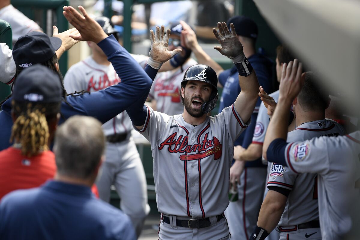 Atlanta Braves' Dansby Swanson celebrates his two-run home run in the dugout during the third inning of a baseball game against the Washington Nationals, Sunday, Aug. 15, 2021, in Washington. (AP Photo/Nick Wass)