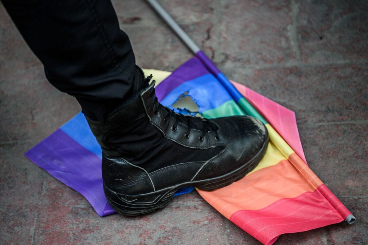 A Turkish anti-riot police officer steps on a rainbow flag during a rally staged by the LGBT community in Istanbul on June 19, 2016.
