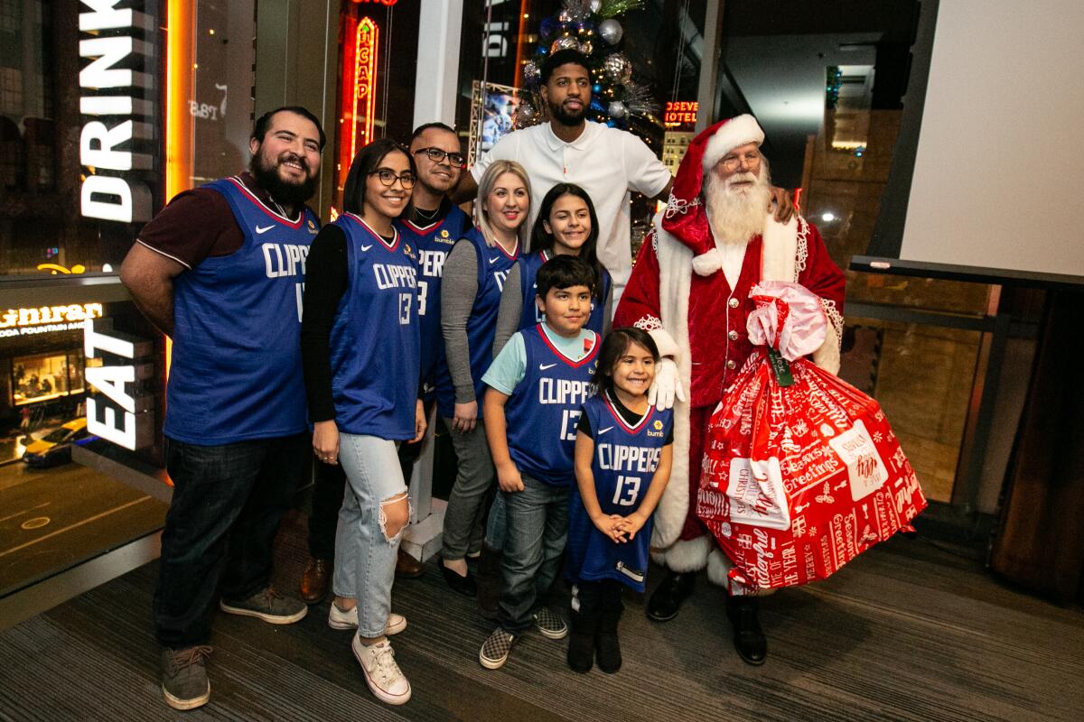 Paul George and Santa take a photo with the Rios family.