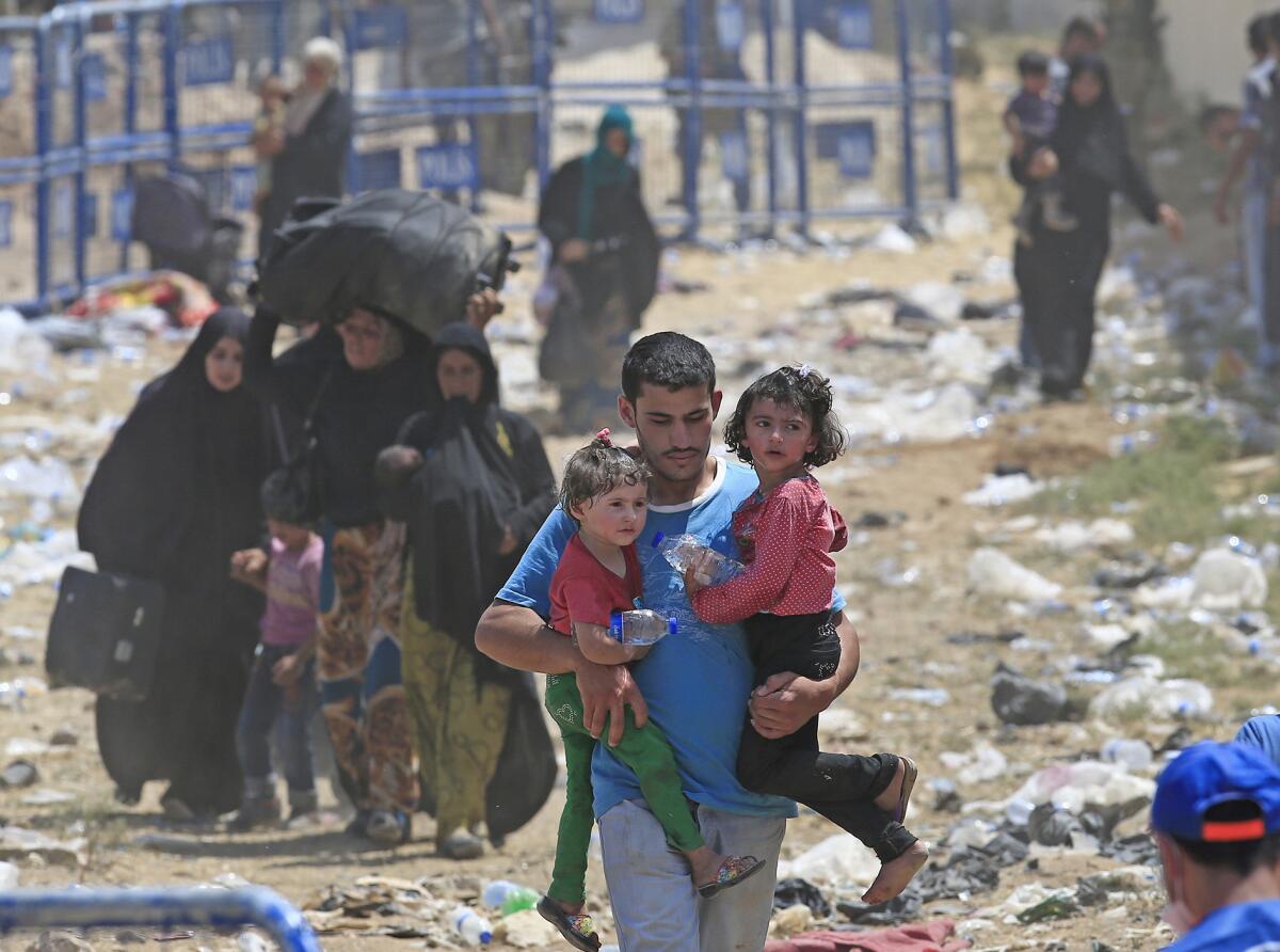 Un refugiado sirio lleva a dos niños en Akcakale, sureste de Turqií adonde han llegada oleadas de personas que escapan de los duros combates enrtre milicias curdas y extremistas del grupo Estado Islámico el lunes 15 de junio de 2015. (Foto AP/Lefteris Pitarakis)