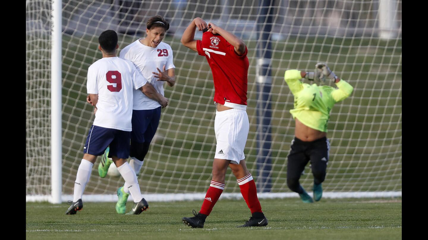 Estancia High's Rafael Espinoza, center, and goalkeeper Yonathan Lopez, right, react after La Quinta's Cesar Rodriguez (29) scores a penalty kick in overtime to defeat the Eagles, 2-1, in the second round of the CIF Southern Section Division 3 playoffs on Wednesday at La Quinta High School.