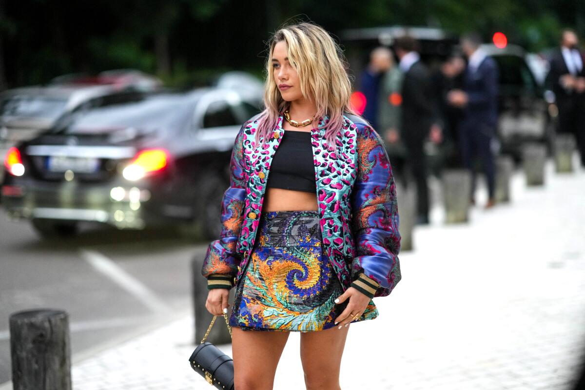 A woman wearing a colorful outfit on the street.