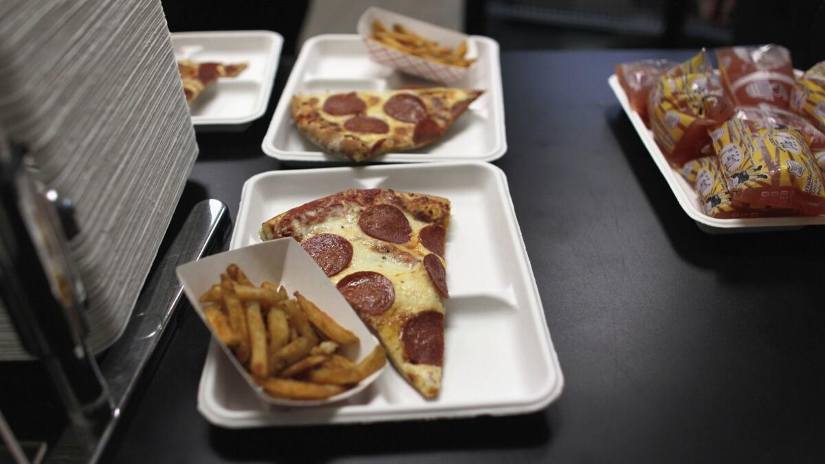 Pizza slices and french fries are served for lunch at a high school in Miramar, Fla.