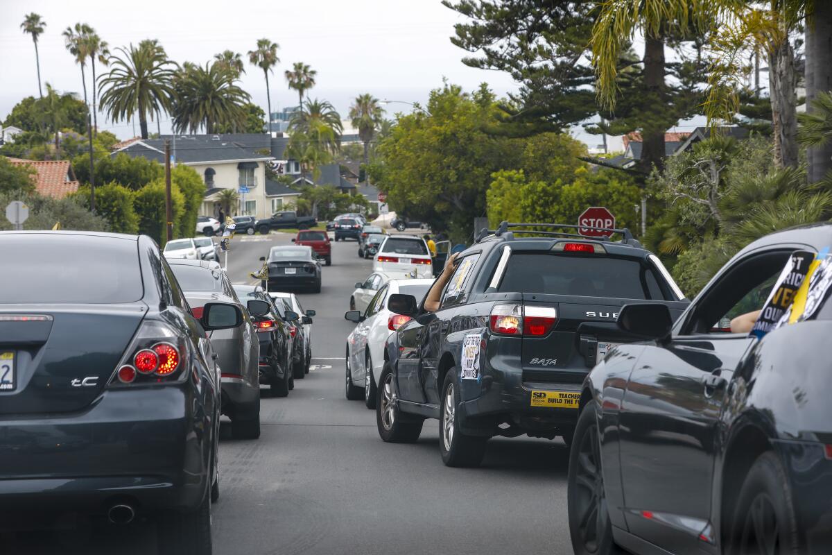 A protest caravan moves through a La Jolla neighborhood on July 1.