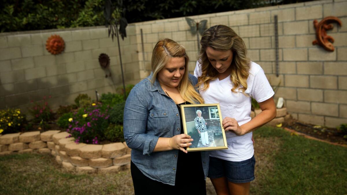 Halie Griffin and her sister Katie Howe hold a photo of their late grandmother, Julie Shepherd, who died after contracting the West Nile virus.