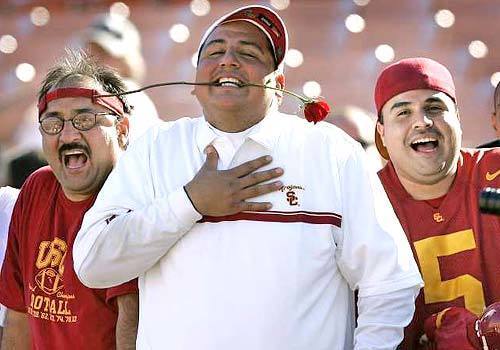 Southern California fans Manuel Hernandez, Sr., left, son Manuel Hernandez, Jr., center, and friend Nick Ponomaroff cheer for the Trojans.