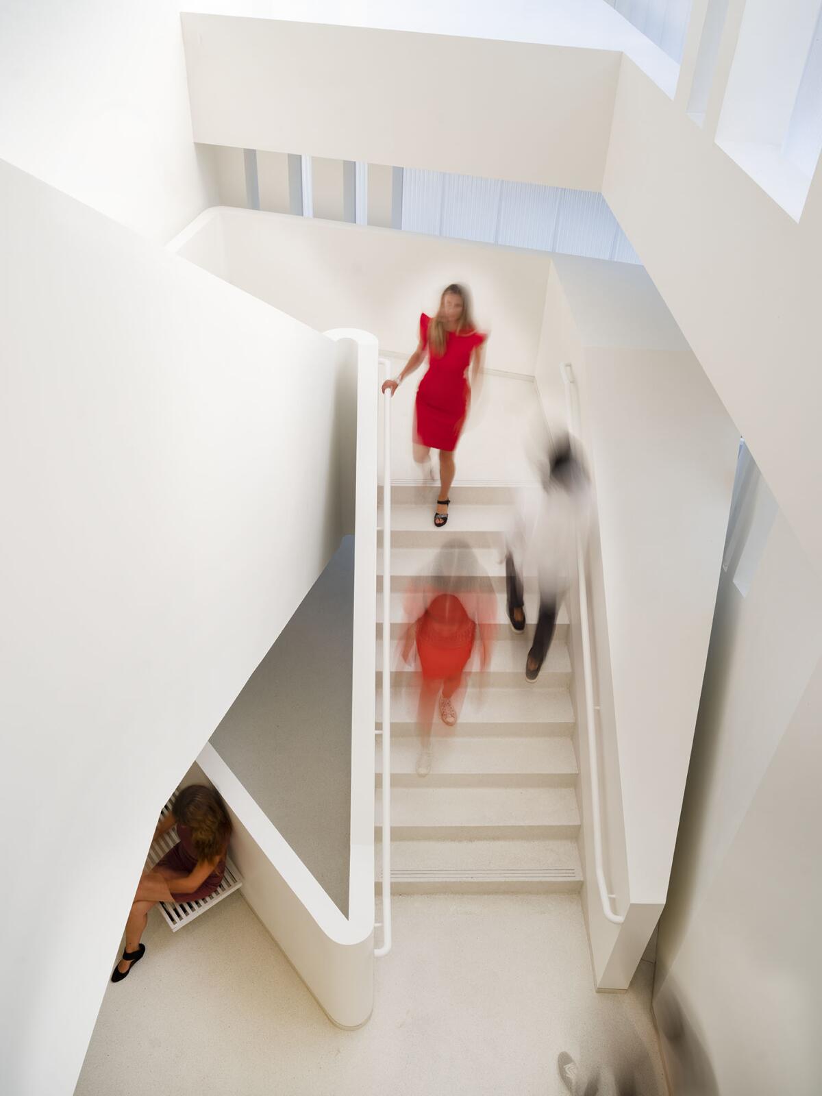 An overhead view shows people ascending and descending a set of gracefully designed stairs.