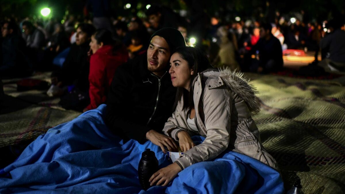 A couple watch the movie "Roma" by Mexican director Alfonso Cuaron, in the former presidential residence of Los Pinos, now converted into a cultural center in Mexico City on Thursday.