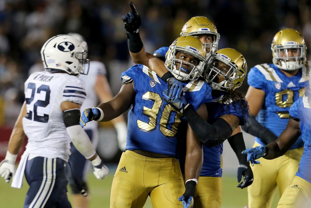 UCLA linebacker Myles Jack is congratulated by teammates after intercepting a pass to seal a 24-23 victory over BYU at the Rose Bowl on Saturday .