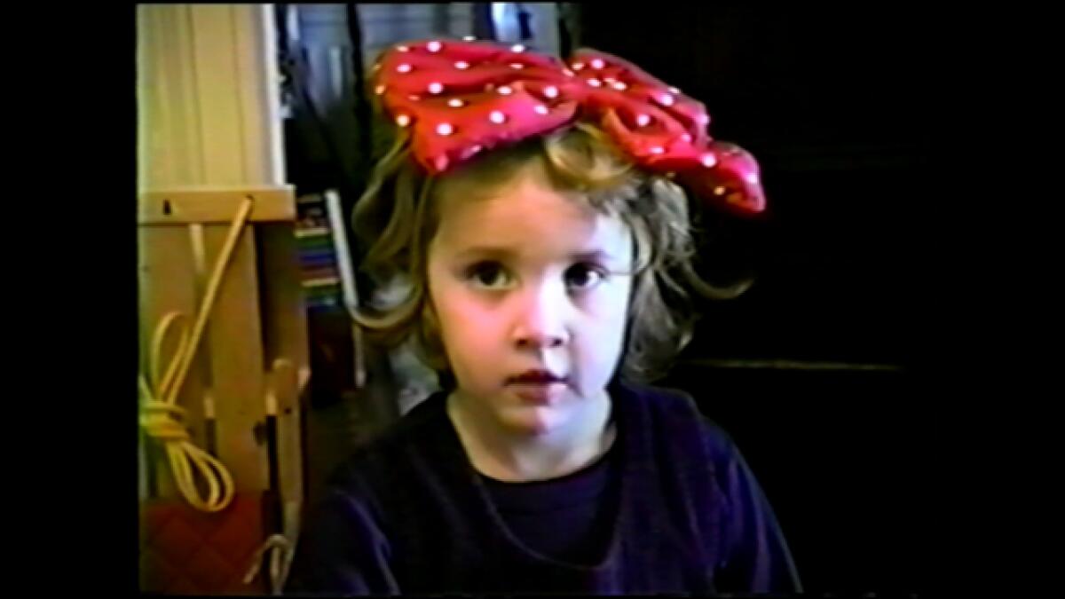 A young Dylan Farrow, with a red and white polka dot bow in her hair, captured on camcorder in HBO's "Allen v. Farrow."
