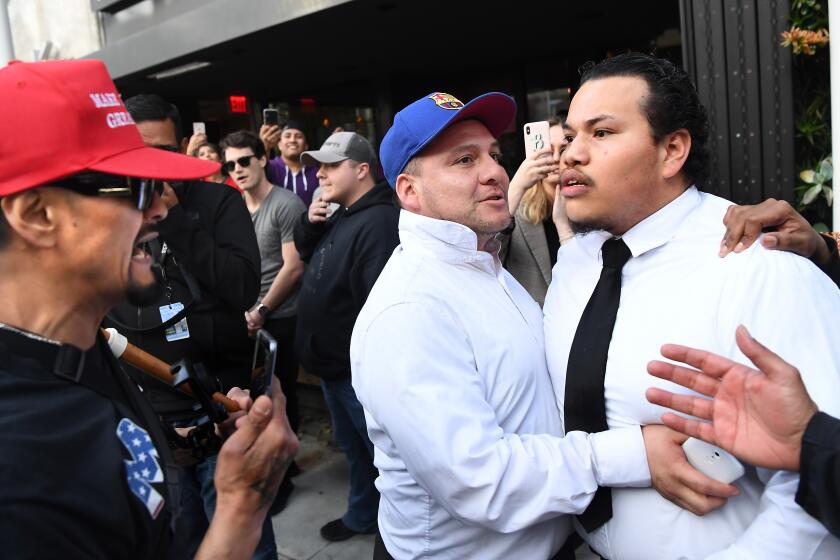 BEVERLY HILLS, CALIFORNIA FEBRUARY 18, 2020-A Trump protetor is held back as he argues with a Trump supporter before the arrival of the president outside the Montage Hoel in Beverly Hills Tuesday. (Wally Skalij/Los Angeles Times)