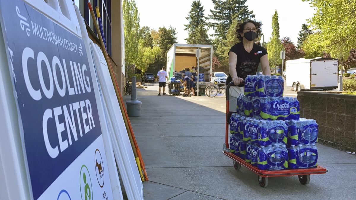 A person pushes a cart with water bottles.