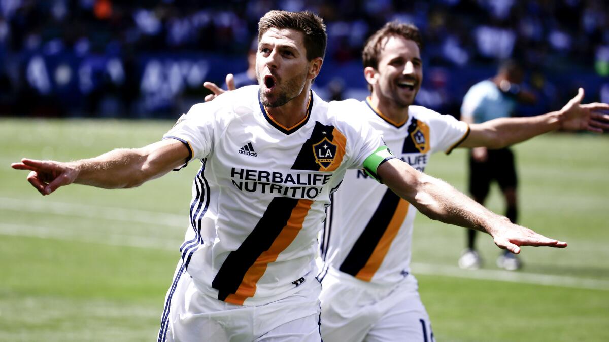 Galaxy midfielder Steven Gerrard, left, celebrates his goal with Mike Magee during the second half of a game against the Revolution on May 8.