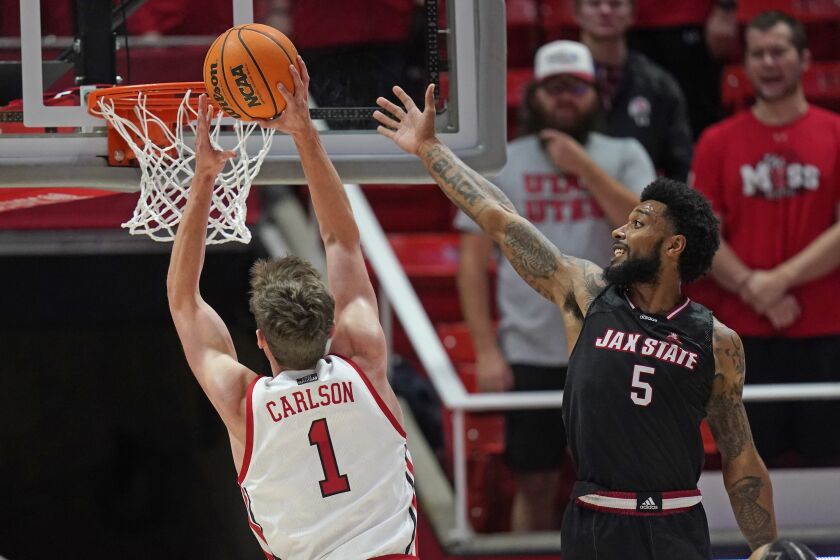 Utah forward Ben Carlson (1) goes to the basket as Jacksonville State guard Skyelar Potter (5) defends during the first half of an NCAA college basketball game Thursday, Dec. 8, 2022, in Salt Lake City. (AP Photo/Rick Bowmer)