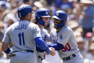Los Angeles Dodgers' Mookie Betts, right, celebrates with teammates James Outman, center.