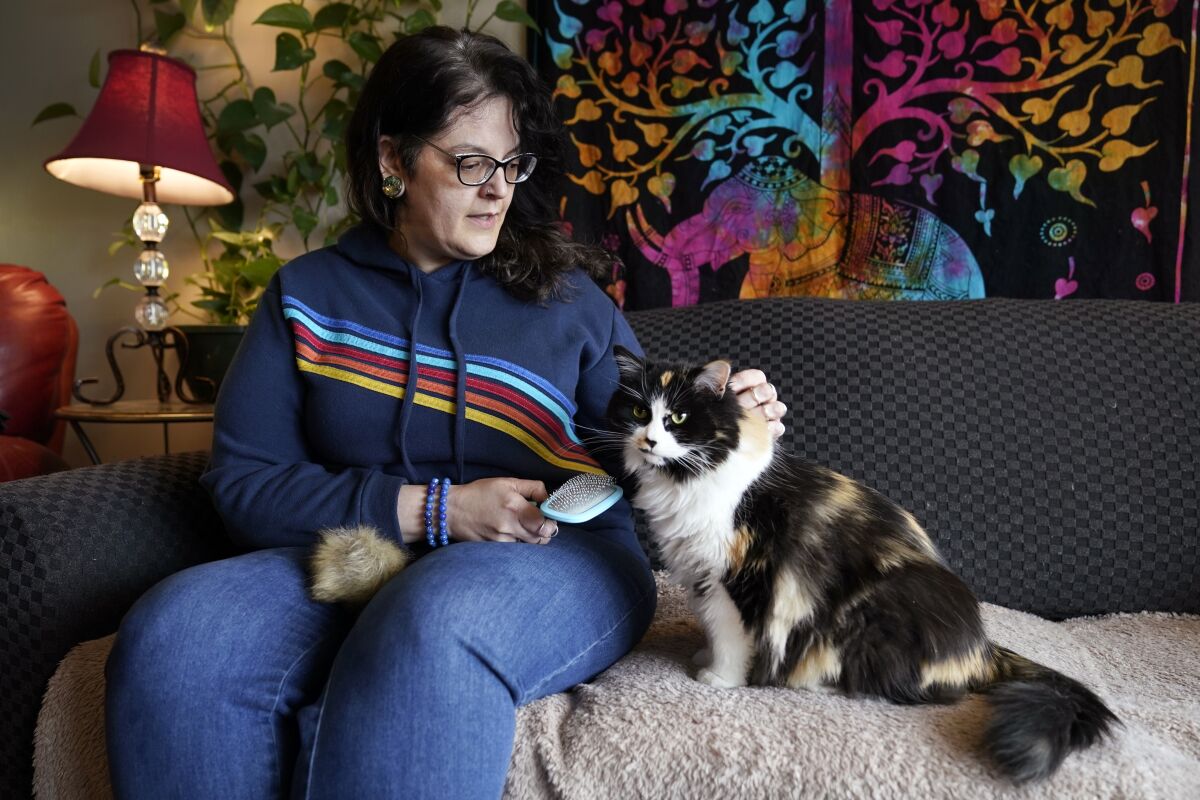 Tara Kramer sits in her apartment with her cat Busy.