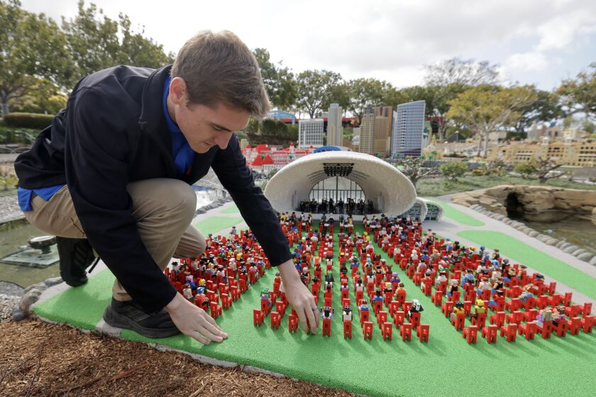 Master Model Builder Carter Cummings, 26, makes an adjustment at the Rady Shell, which is part of Miniland San Diego, at Legoland on Saturday, March 25, 2023.