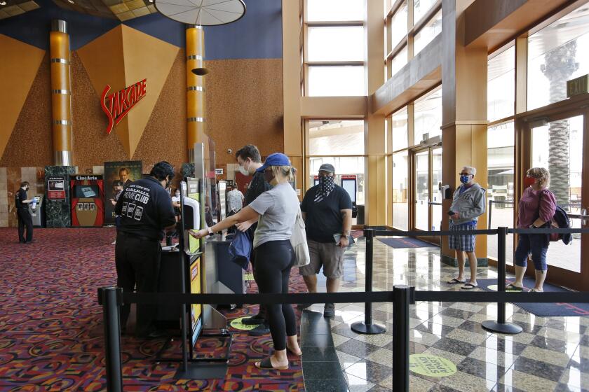 Movie fans buy their tickets minutes after Cinemark Century Cinema opened, in Huntington Beach on Friday, Sept. 11, 2020.