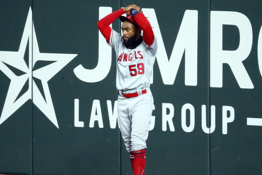 Los Angeles Angels right fielder Jo Adell puts his hands on his head after a fly ball by Texas Rangers' Nick Solak.