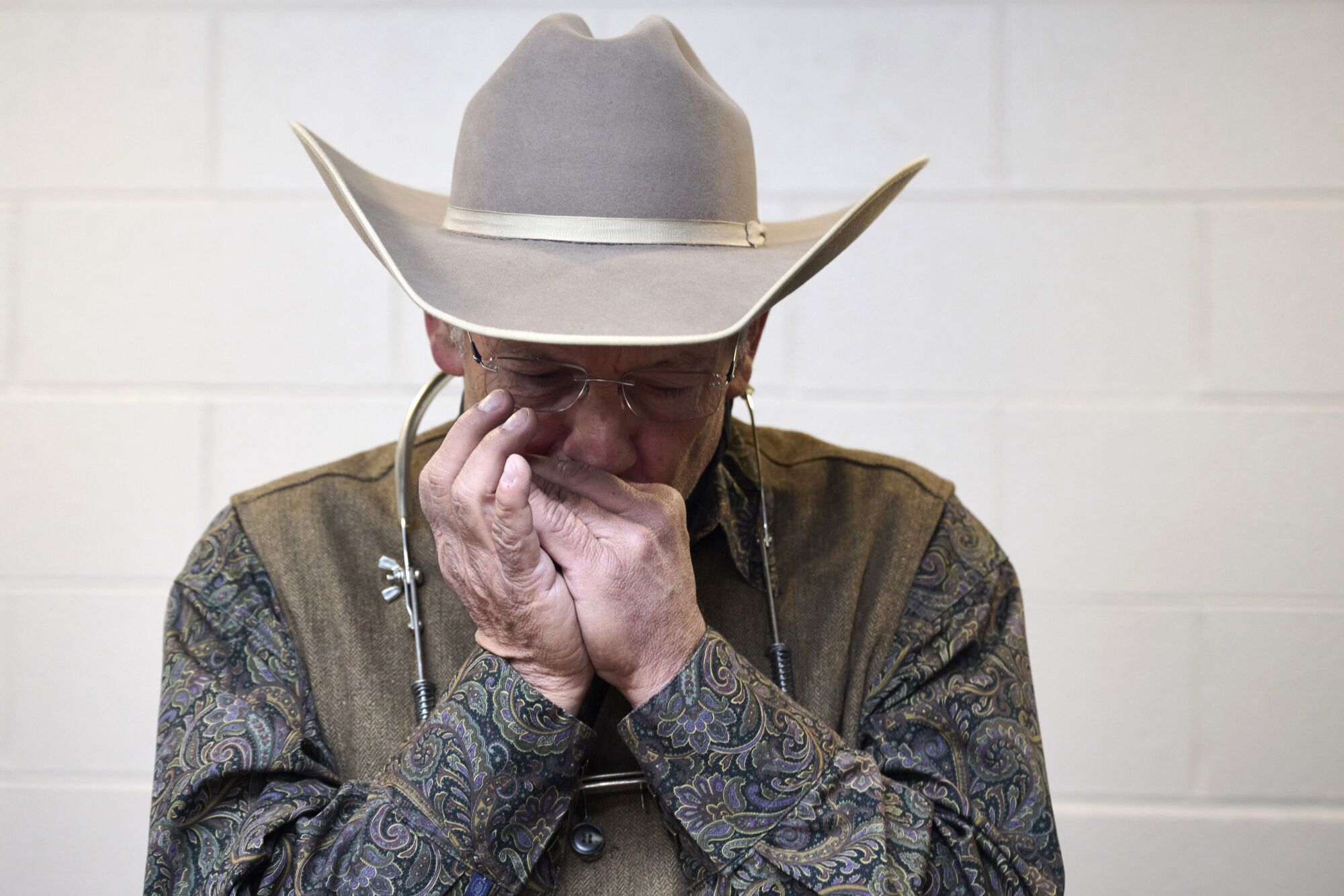 Le musicien Gene Bieder se réchauffe dans les coulisses du National Cowboy Poetry Gathering le 3 février à Elko, Nevada.