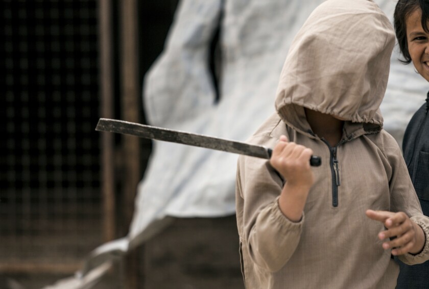 FILE - A boy plays with a broken sword, at al-Hol camp, which houses families of members of the Islamic State group, in Hasakeh province, Syria, May 1, 2021. Hundreds of minors are believed to be holed up in Gweiran Prison, which has been at the center of an ongoing violent standoff between Islamic State group militants and U.S.-backed Kurdish fighters after IS fighters stormed the prison on Thursday, Jan. 20, 2022. A distressing series of voice notes sent by an Australian teenager from the prison in northeast Syria underscores the plight of thousands of forgotten children that remain trapped in detention facilities in Syria and Iraq. (AP Photo/Baderkhan Ahmad, File)