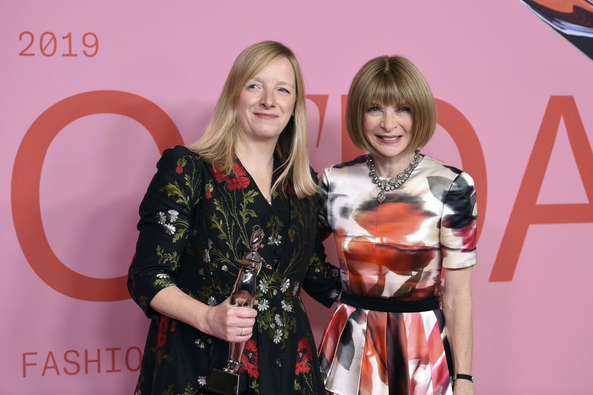 Honoree Sarah Burton, left, poses in the winner's walk with the Valentino Garavani and Giancarlo Giammetti International Award and Vogue Editor in Chief Anna Wintour at the CFDA Fashion Awards at the Brooklyn Museum in New York on Monday.