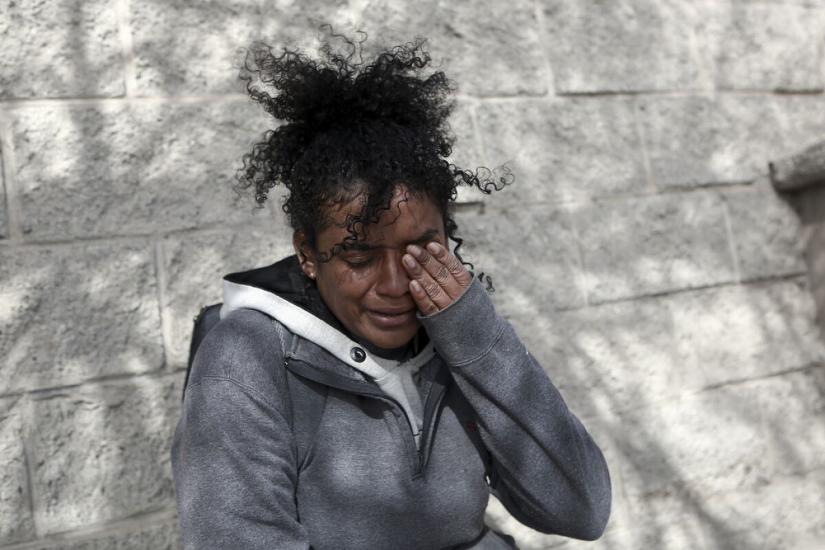 Una mujer migrante venezolana llora a las afueras de un centro de detención de migrantes 
