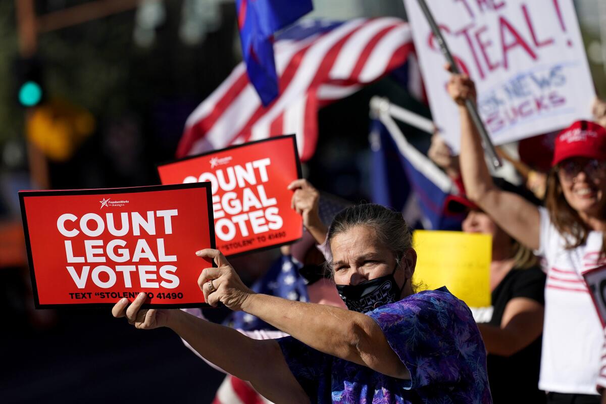 Protesters with red signs that say Count Legal Votes