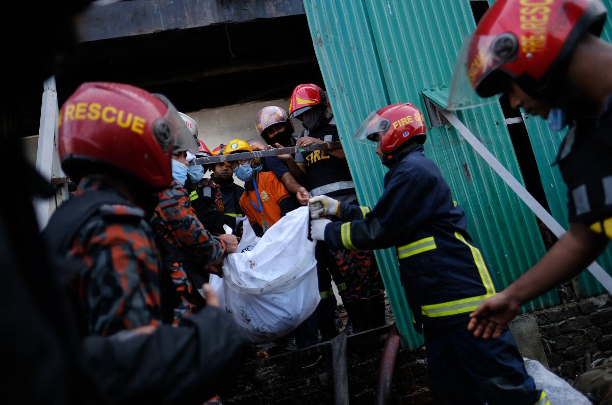 Firefighters carrying body of fire victim