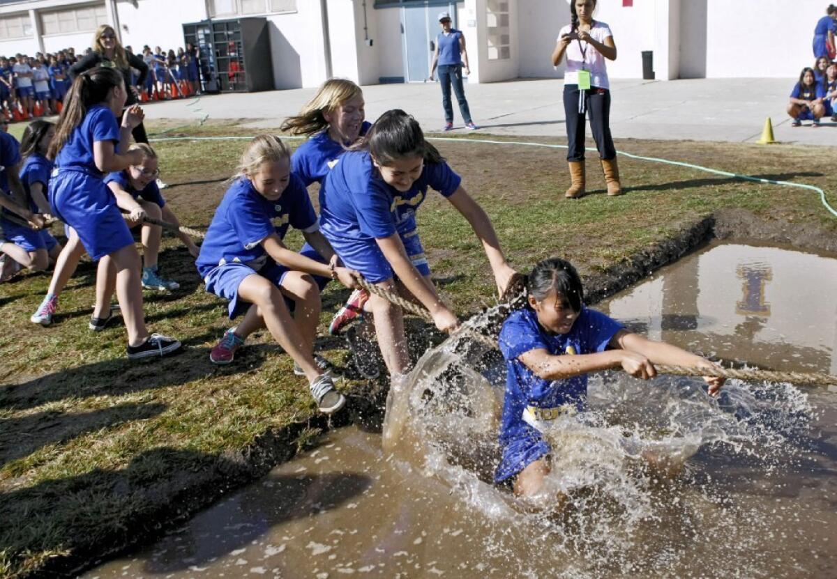 A team of seventh grade girls are pulled into muddy waters as their team looses a tug-of-war heat at Wilson Middle Schoo