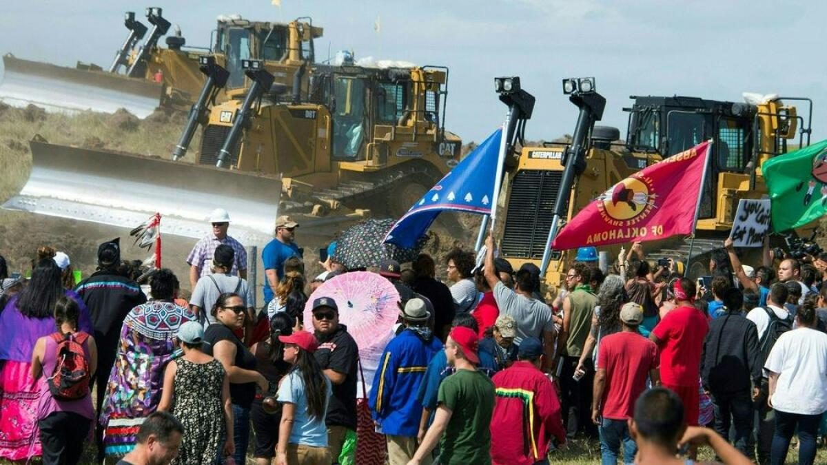 Members of the Standing Rock Sioux tribe and supporters confront bulldozers working on the Dakota Access Pipeline in an effort to make them stop.