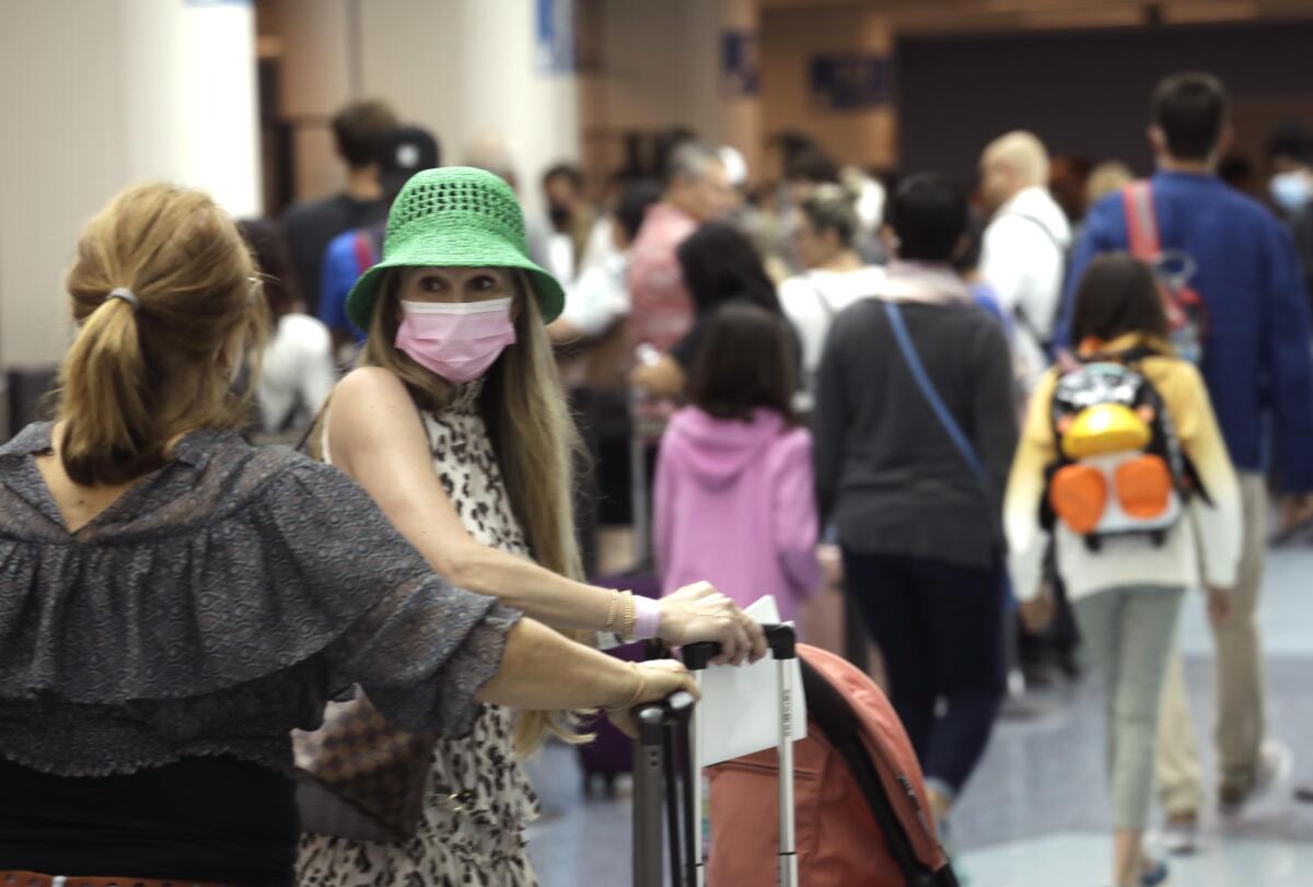 Travelers at Los Angeles International Airport wear masks in May 2022.